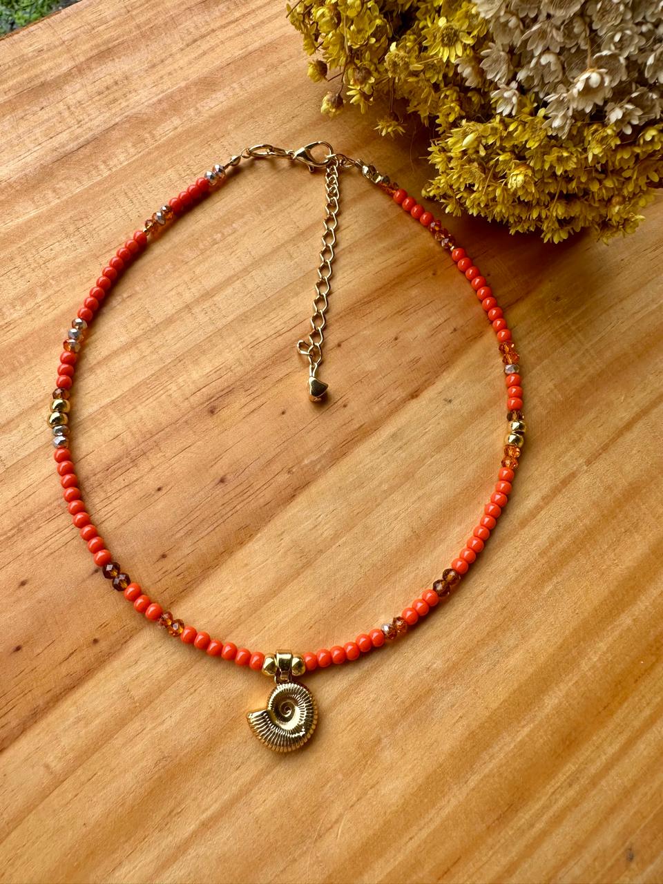 Colar artesanal coral com pingente dourado em forma de concha